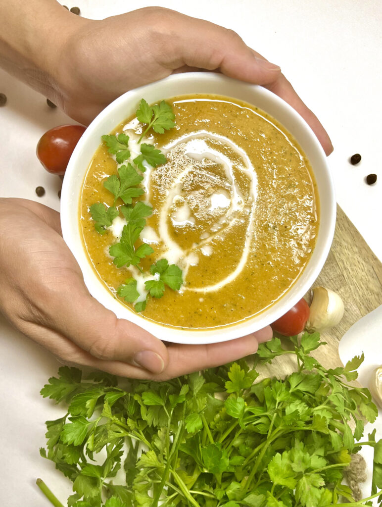 tomato soup in bowl with hands