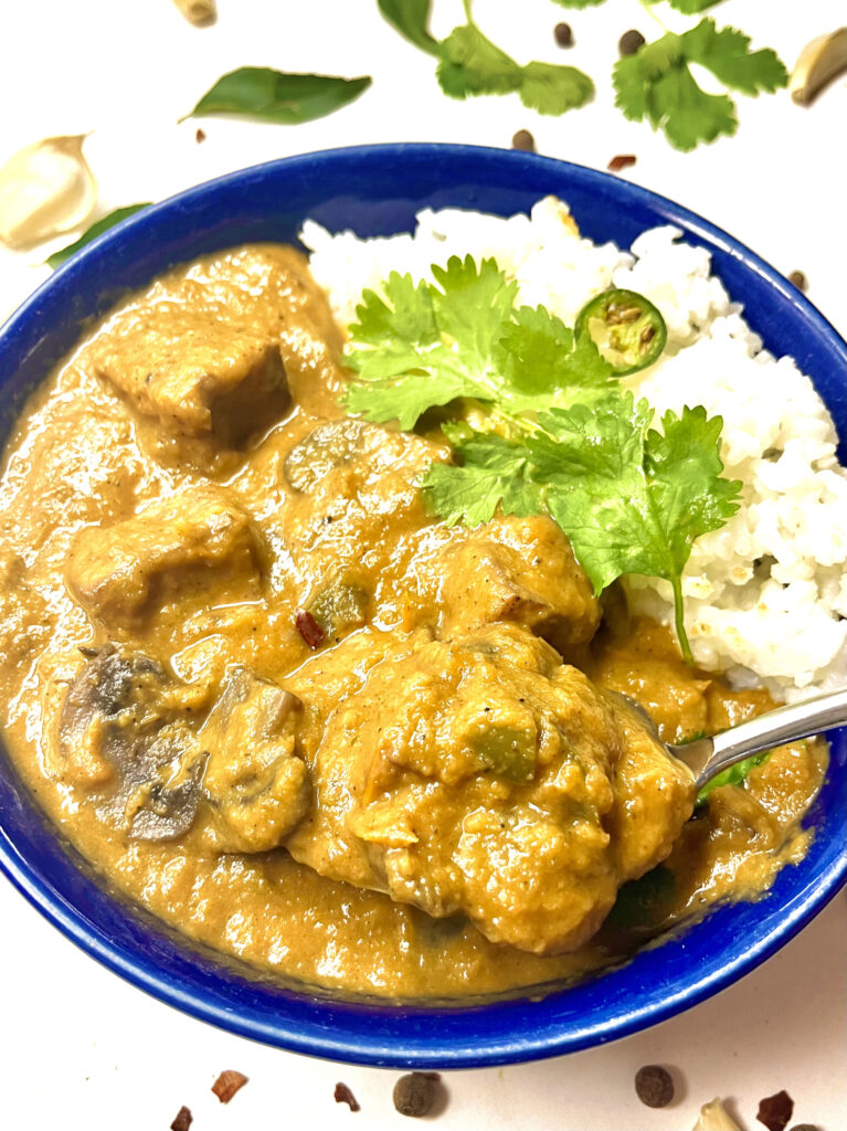 cajun tofu mushroom coconut curry plated with spoon