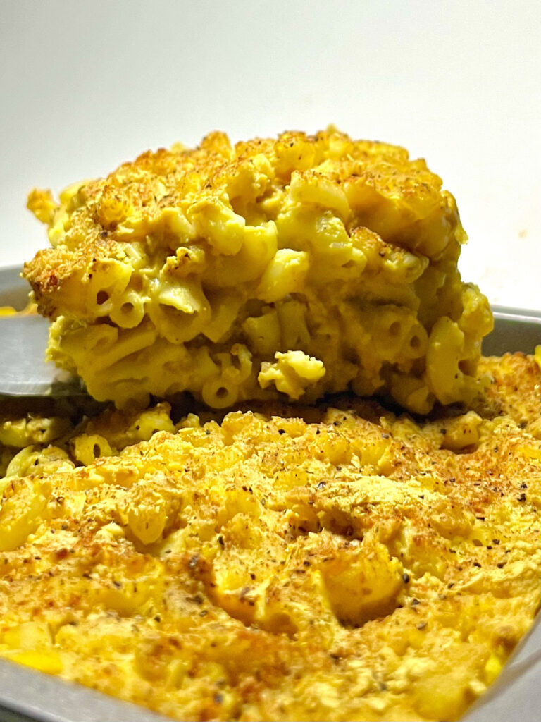 slice of mac and cheese above pan