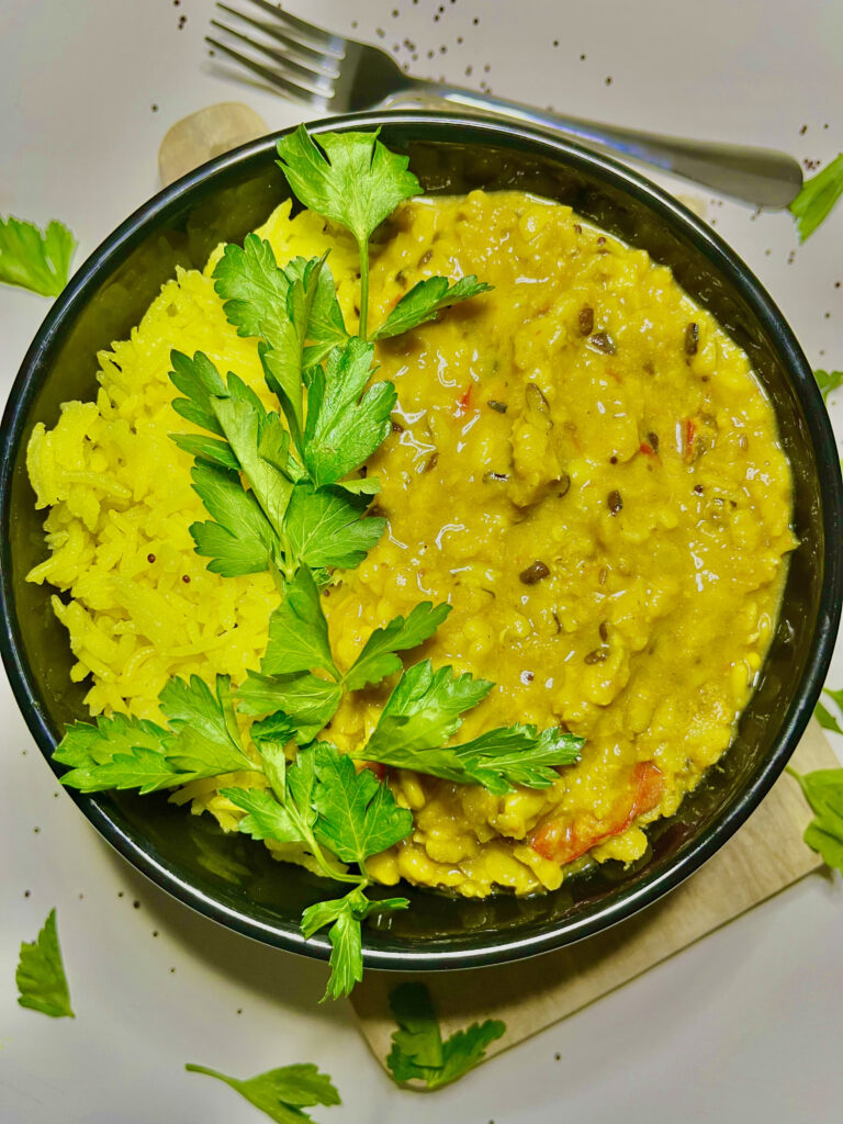 coconut turmeric rice with garnish on black plate