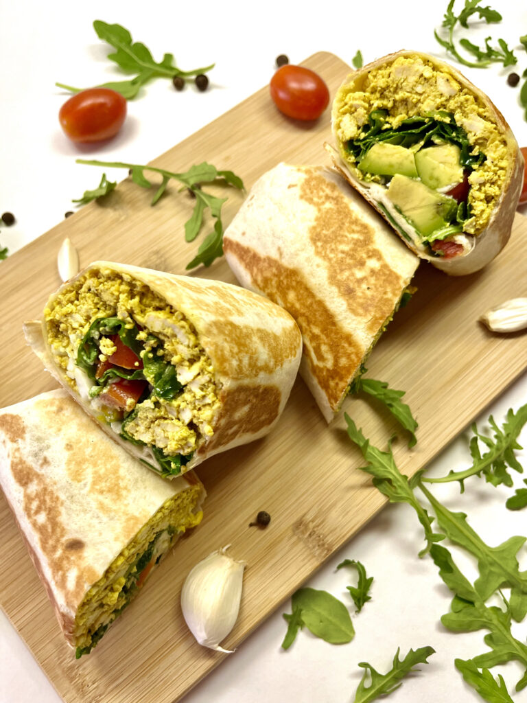 breakfast burrito halves on wooden board