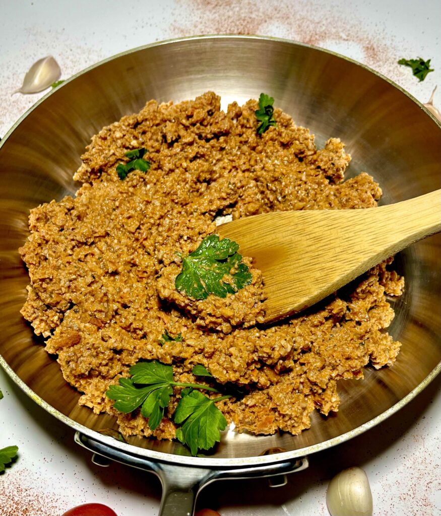 cooked walnut meat in pan with wooden spoon